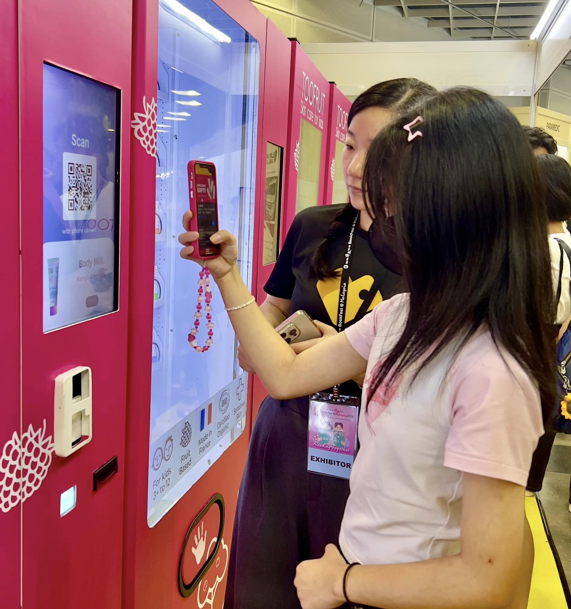 Customer scanning a pink smart vending machine with phone